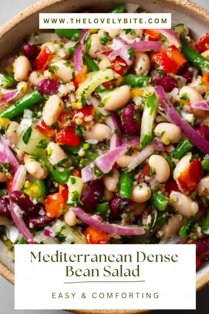 This Mediterranean Dense Bean Salad features a vibrant mix of beans, crisp vegetables, sliced Kalamata olives, and vegan feta cheese. It is a healthy bean salad with bright Mediterranean colors and a fresh homemade dressing.
