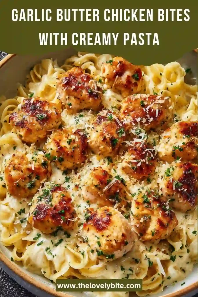 Close-up of creamy Parmesan pasta topped with garlic butter chicken bites, rich sauce coating every piece.