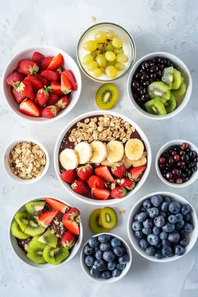 Close-up of an easy acai bowl topped with sliced strawberries, blueberries, and crunchy granola on a creamy base.