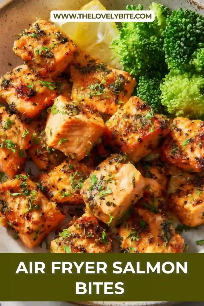 Air fryer salmon bites arranged in a basket, evenly cooked and lightly crisped. Garnished with lemon wedges for extra flavor.
