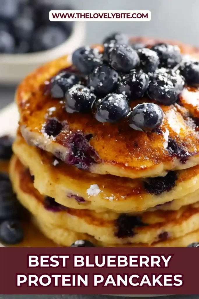 A stack of blueberry protein pancakes topped with fresh blueberries and maple syrup on a plate, showcasing a healthy breakfast option.