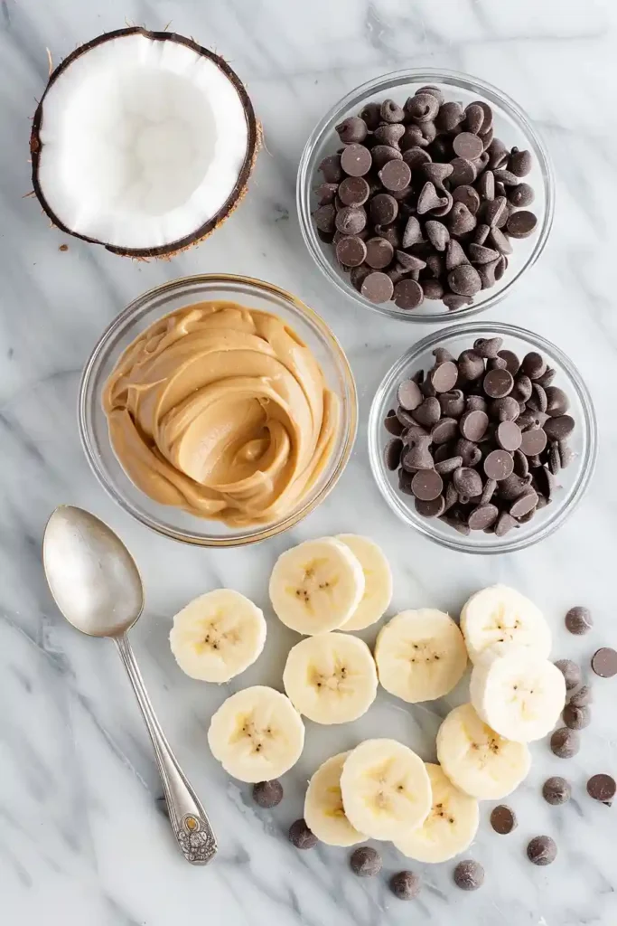 A tray of Chocolate Peanut Butter Banana Bites with banana slices sandwiched with peanut butter and dipped in dark chocolate. These frozen banana bites look creamy, rich, and perfect for a quick homemade snack.