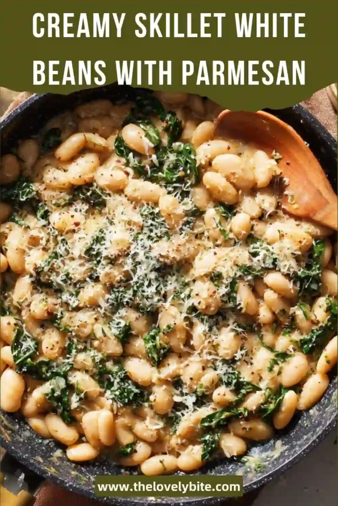 Creamy Skillet White Beans with Parmesan served in a rustic pan with fresh herbs and wilted greens in a rich sauce.