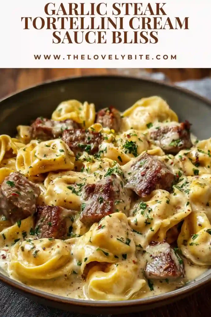 Close-up of creamy garlic steak tortellini with parmesan and cracked black pepper. The sauce appears thick and velvety.