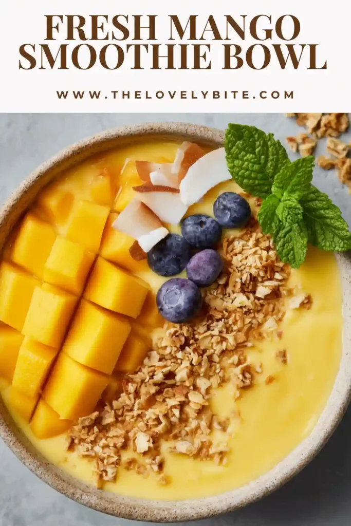 A creamy mango yogurt bowl served cold and topped with banana slices, fresh berries, and shredded coconut. This tropical smoothie bowl is a simple and beautiful breakfast idea with bright fruit flavor.