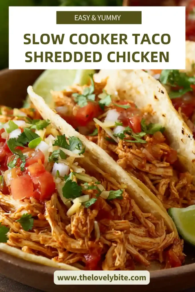 A serving of Slow Cooker Taco Shredded Chicken tucked into taco shells with fresh toppings. The chicken is soft, well-seasoned, and perfect for a healthy taco night.