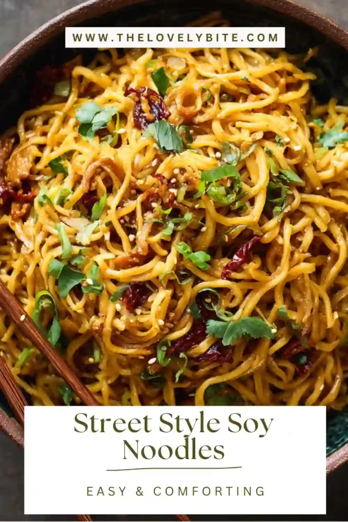 Close-up of Street Style Soy Noodles featuring tender chicken strips and vegetables coated in a dark soy glaze. The dish has a vibrant and appetizing texture.