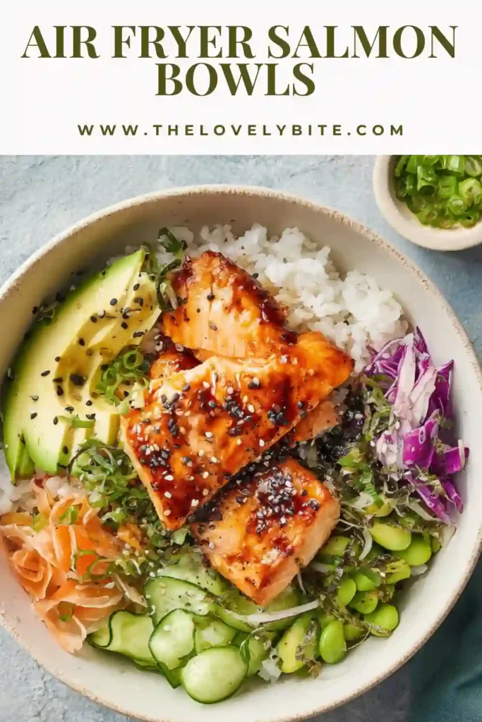 Close-up of crispy air fryer salmon cubes on a rice bowl with sesame seeds and vegetables. A healthy Air Fryer Salmon Bowls meal.