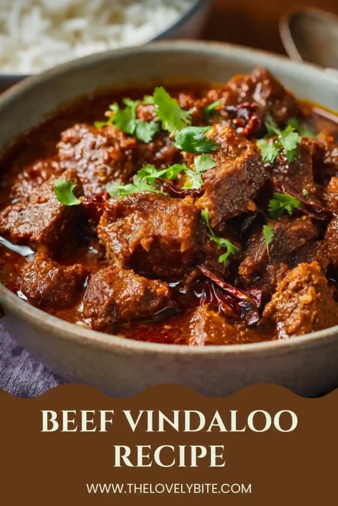 Traditional-style Beef Vindaloo prepared with marinated beef, tomatoes, garlic, and spices in a vibrant curry sauce. This spicy beef curry recipe is ideal for cozy family dinners.