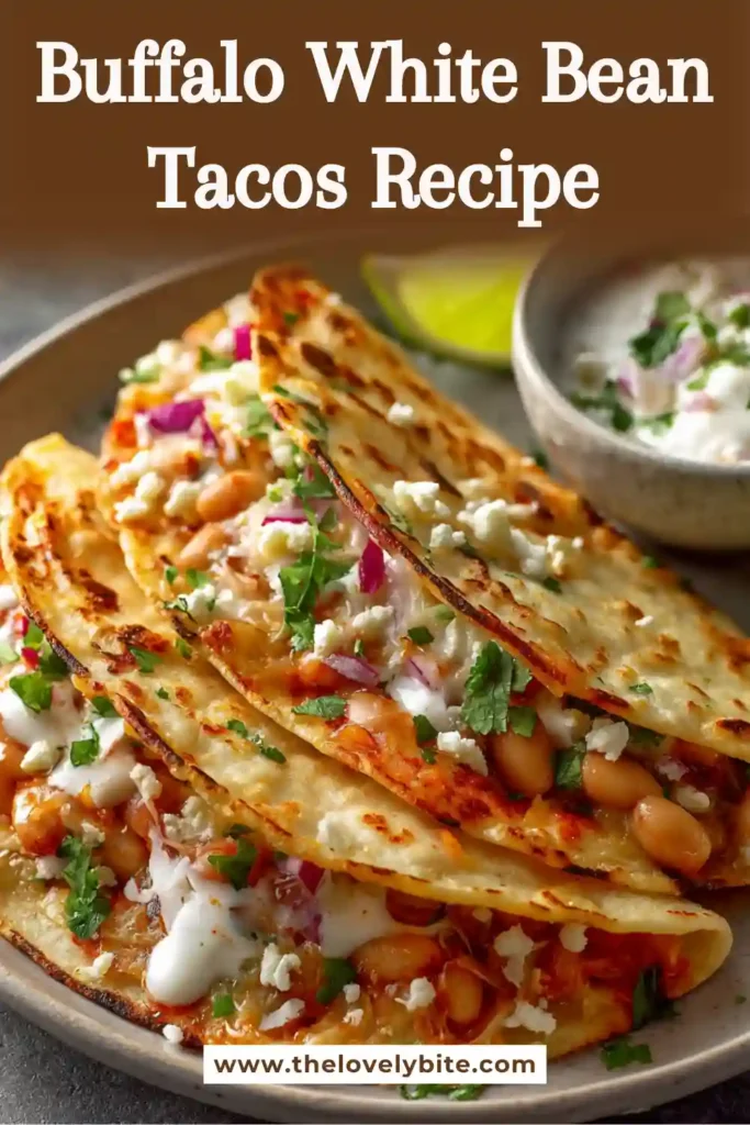 Easy Buffalo White Bean Tacos arranged on a serving plate with fresh cilantro and diced tomatoes. These vegetarian buffalo tacos are packed with bold flavor and texture.