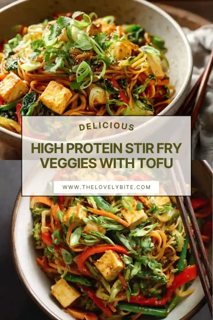 A bowl of High Protein Stir Fry Veggies with Tofu served with ramen noodles, colorful vegetables, and fresh basil. The vegan stir fry is coated in a savory sesame sauce and topped with green onions.