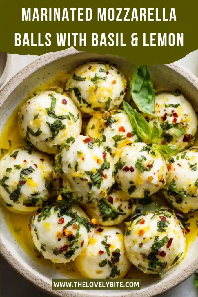 Fresh Marinated Mozzarella Balls soaking in a basil lemon olive oil marinade. The creamy mozzarella is garnished with herbs and served as an elegant party appetizer.