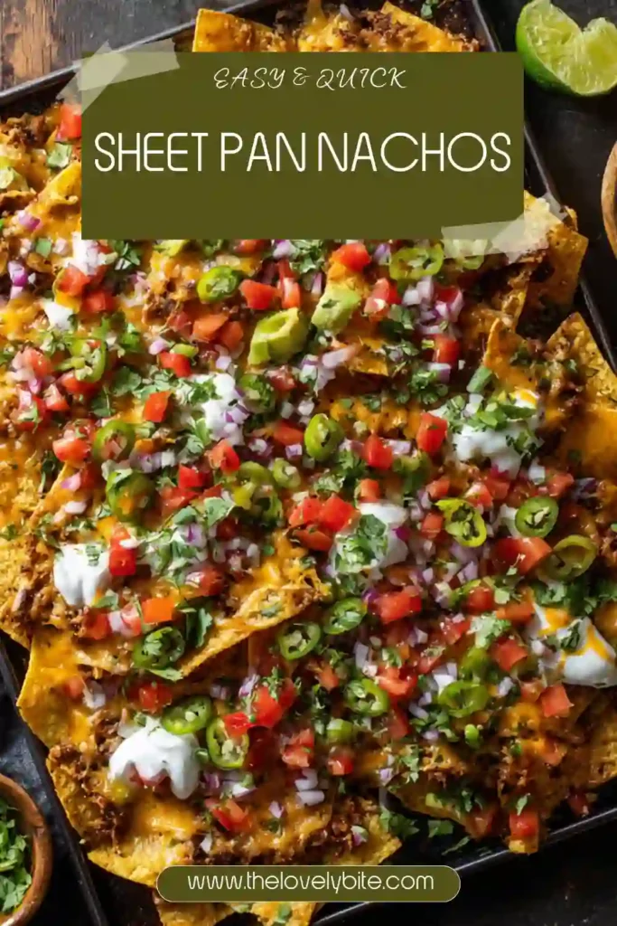 Freshly baked Sheet Pan Nachos loaded with gooey cheese, ground beef, corn, beans, diced tomatoes, and cilantro on a parchment-lined baking tray. A quick and easy party food recipe.