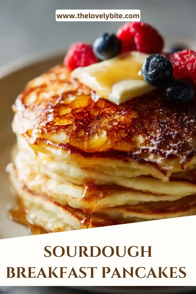 Homemade sourdough breakfast pancakes served warm with powdered sugar and berries on a plate.