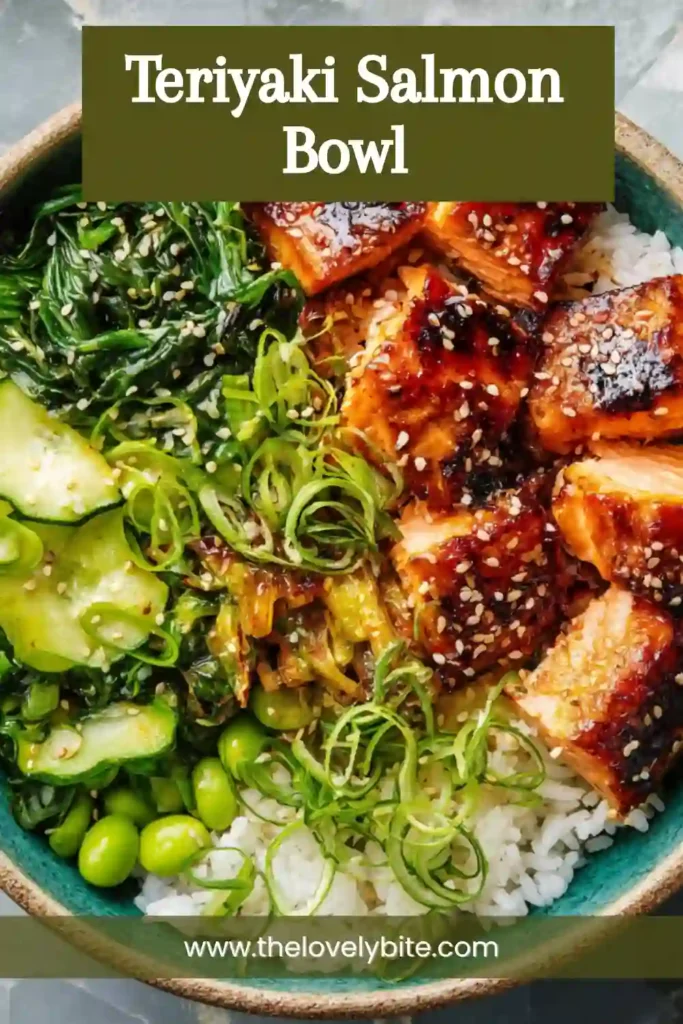 Close-up of a homemade Teriyaki Salmon Bowl with glazed salmon bites over fluffy rice and fresh vegetables. The bowl is garnished with scallions and black sesame seeds.