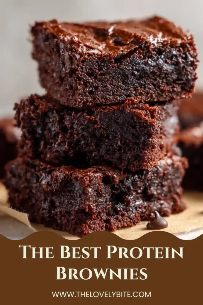 Freshly baked The Best Protein Brownies cooling in a square baking pan with chocolate chips on top. This healthy brownie recipe is packed with protein and deep chocolate flavor.