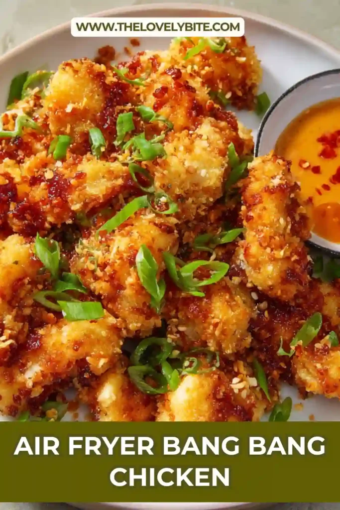 A bowl of Air Fryer Bang Bang Chicken featuring crispy panko-crusted chicken pieces covered in homemade bang bang sauce. Garnished with fresh green onions for extra flavor.