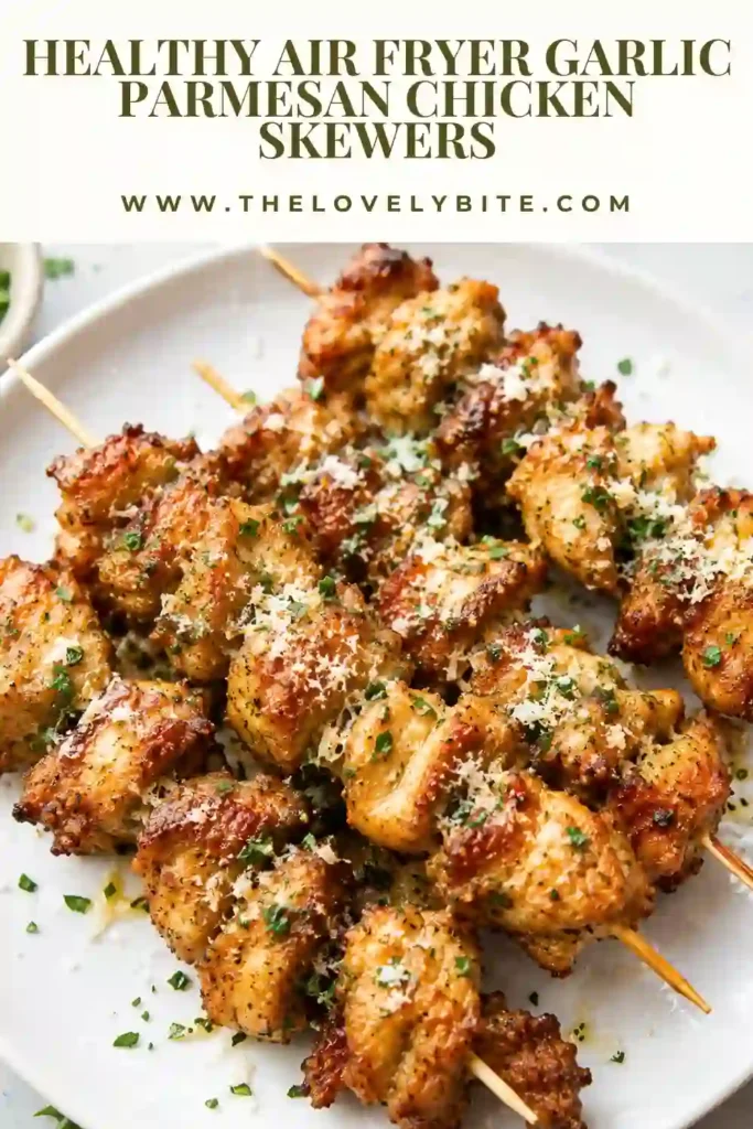 Air Fryer Garlic Parmesan Chicken Skewers arranged on a serving platter with fresh herbs. The chicken has a lightly charred exterior and tender interior.