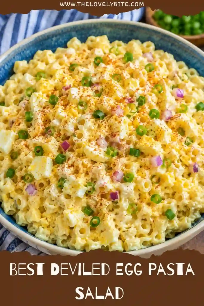 Close-up view of a creamy deviled egg pasta salad topped with paprika and green onions. The salad combines tender pasta and hard-boiled eggs for a comforting meal.