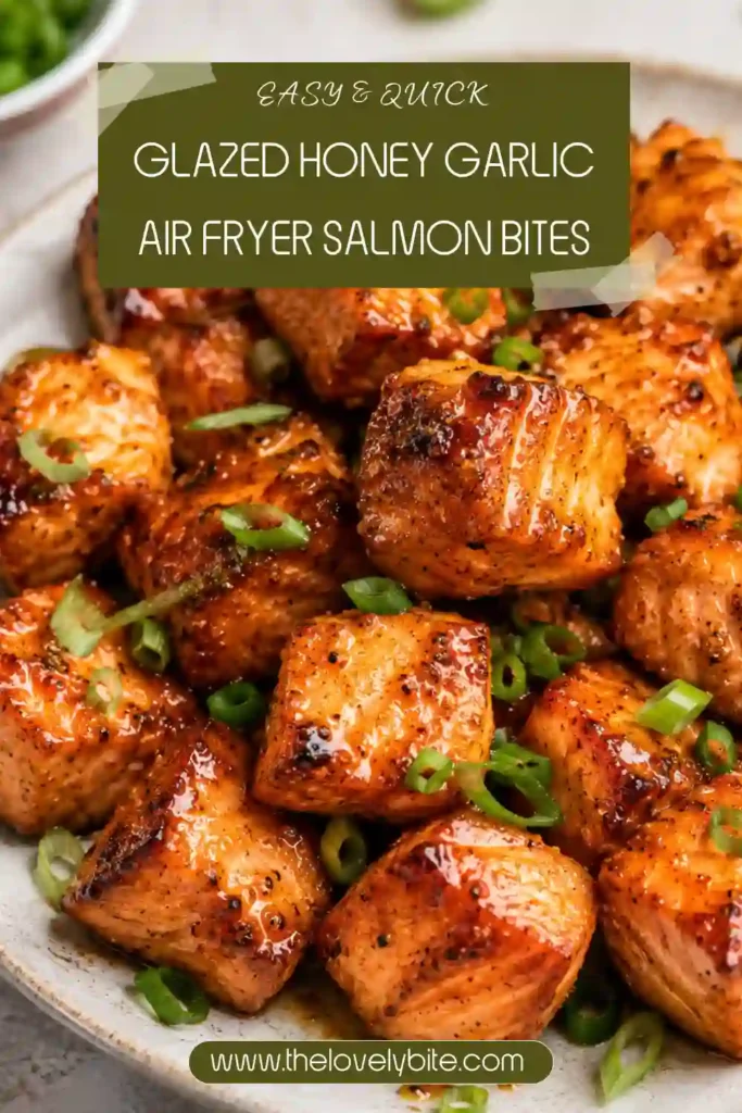 Golden Glazed Honey Garlic Air Fryer Salmon Bites arranged in a serving bowl with rice and vegetables. The salmon appears caramelized, tender, and coated in a shiny honey garlic glaze.