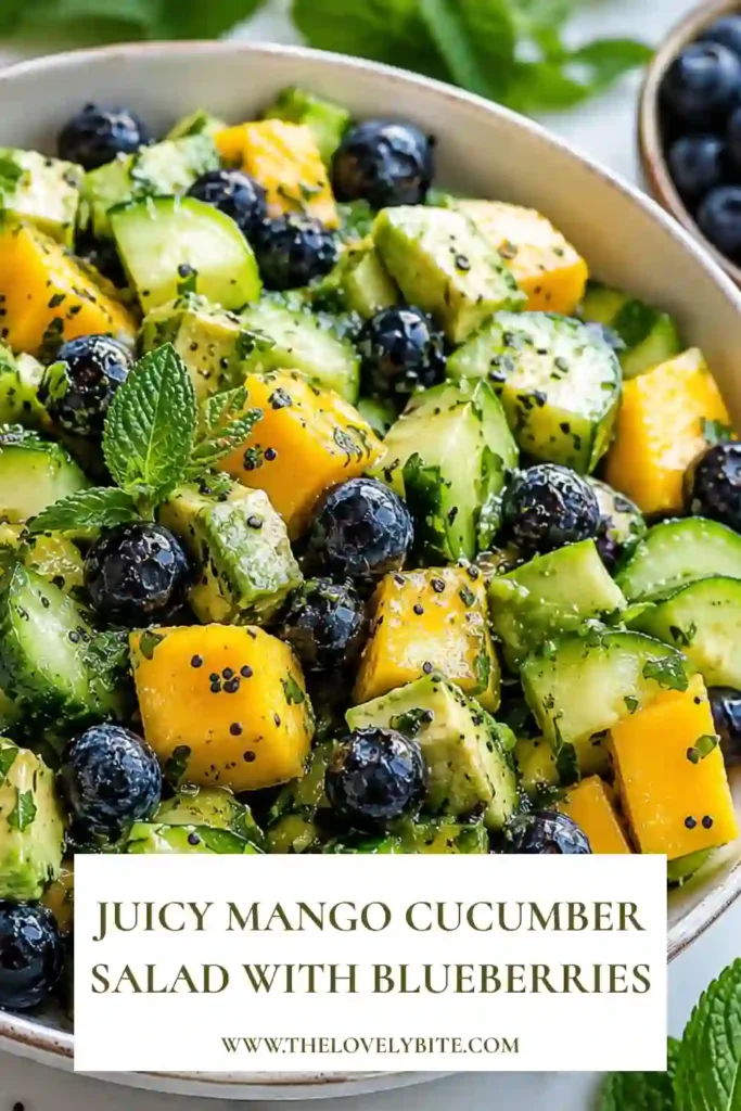 Close-up view of a tropical mango cucumber salad with blueberries and avocado served in a white bowl. Fresh ingredients create a vibrant and nutritious dish.