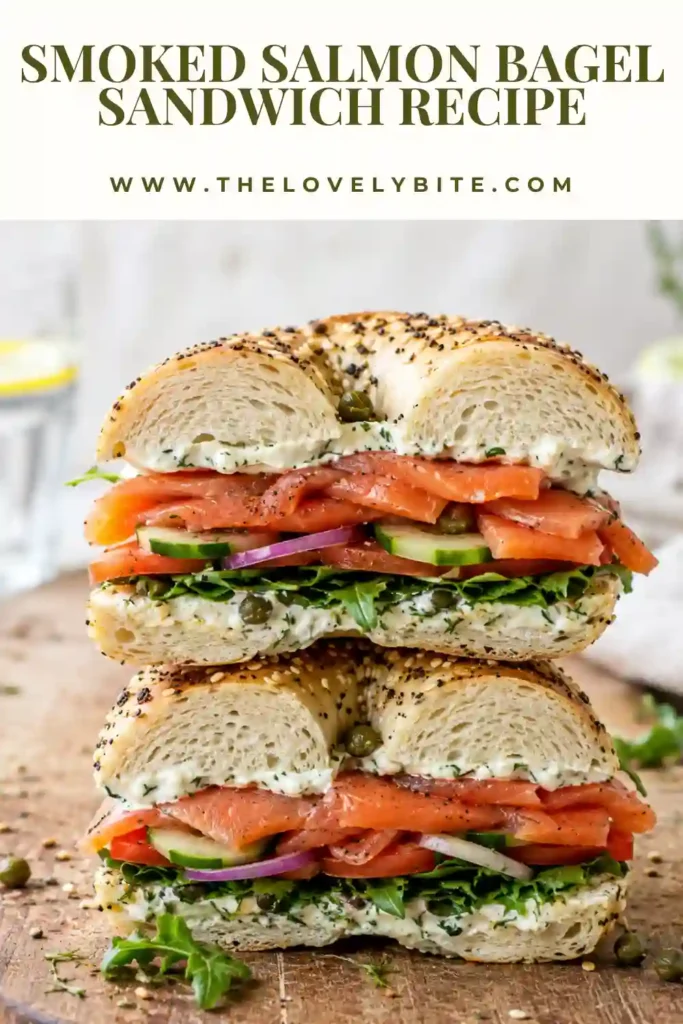 A breakfast bagel sandwich stacked with smoked salmon, tomatoes, cucumber, microgreens, capers, and garlic dill cream cheese. Fresh ingredients create a vibrant and appetizing presentation.