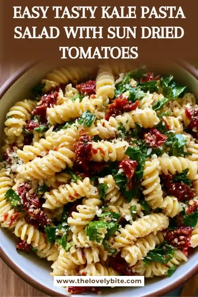 A bowl of Tasty Kale Pasta Salad with Sun Dried Tomatoes featuring rotini pasta, fresh kale, feta cheese, parmesan, and toasted pine nuts. The salad is coated in a vibrant basil-garlic dressing.