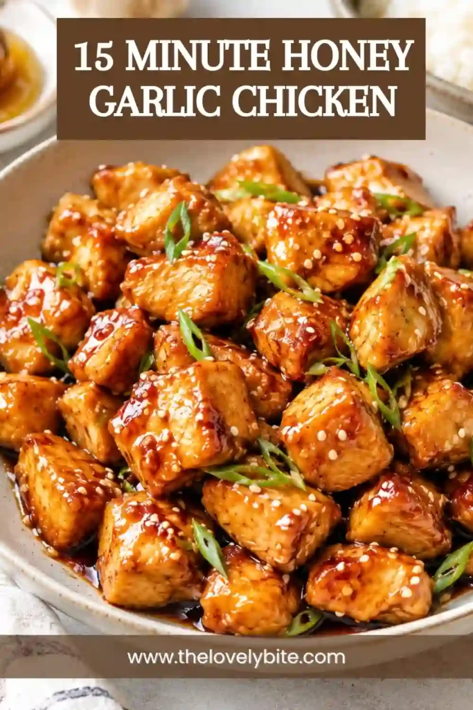 A skillet filled with 15 Minute Honey Garlic Chicken coated in a caramelized honey soy glaze. Fresh garlic, green onions, and sesame seeds complete this easy chicken dinner.