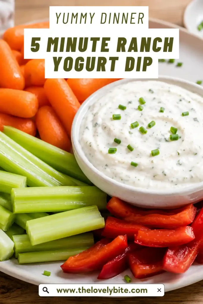 A bowl of creamy 5 Minute Ranch Yogurt Dip garnished with fresh chives and served with colorful fresh vegetables, crackers, and pretzels.