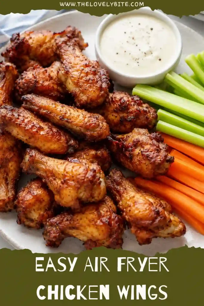 Golden brown Air Fryer Chicken Wings arranged on a serving platter with celery sticks and ranch dressing. The wings have crispy skin and a juicy interior, making them a perfect appetizer.