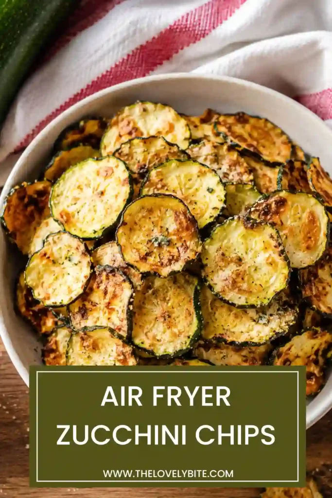Fresh zucchini chips cooked in an air fryer and served with ranch dip on a wooden serving board.