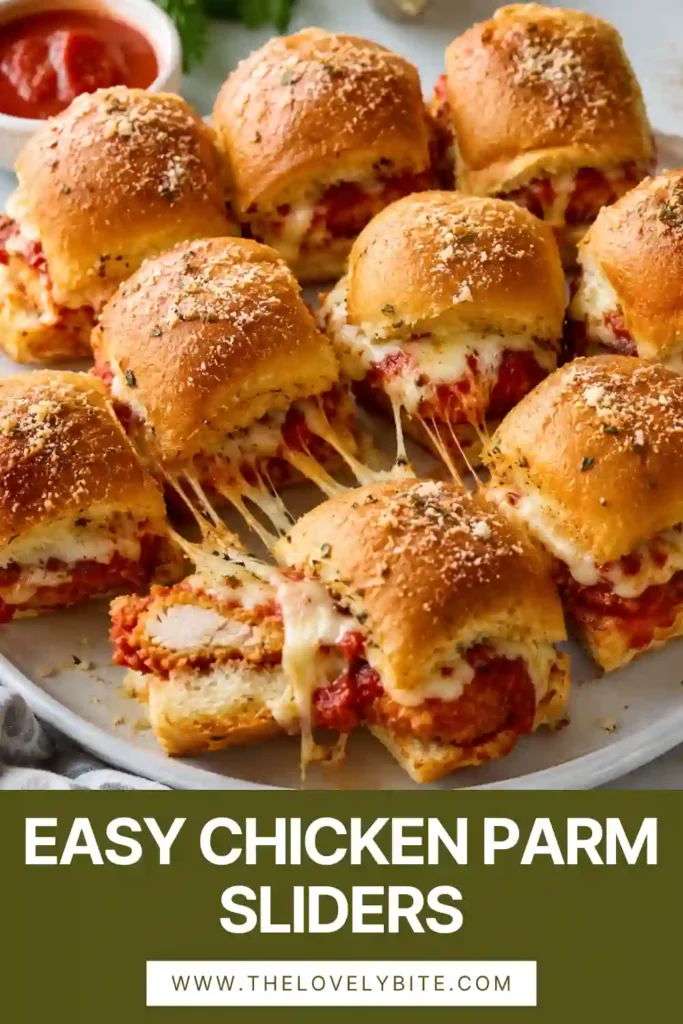 A platter of baked Chicken Parm Sliders served with warm marinara dipping sauce. Crispy chicken and melted cheese create the perfect party appetizer.