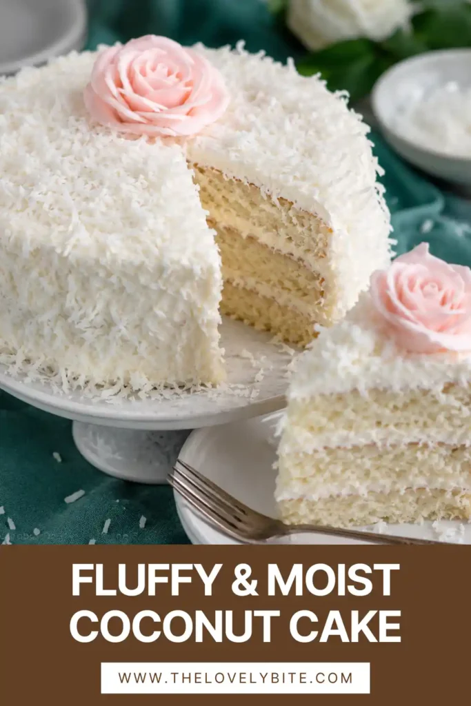 Three-layer coconut cake covered in creamy frosting and sweet shredded coconut, sliced to reveal its soft interior.
