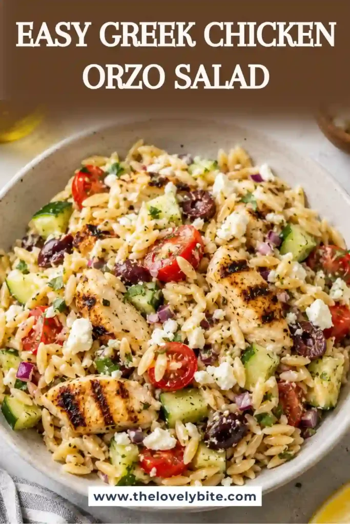 Greek Chicken Orzo Salad served in a large bowl with grilled chicken, feta cheese, cherry tomatoes, cucumbers, roasted peppers, olives, and fresh herbs. The colorful Mediterranean pasta salad is tossed in a homemade herb vinaigrette.