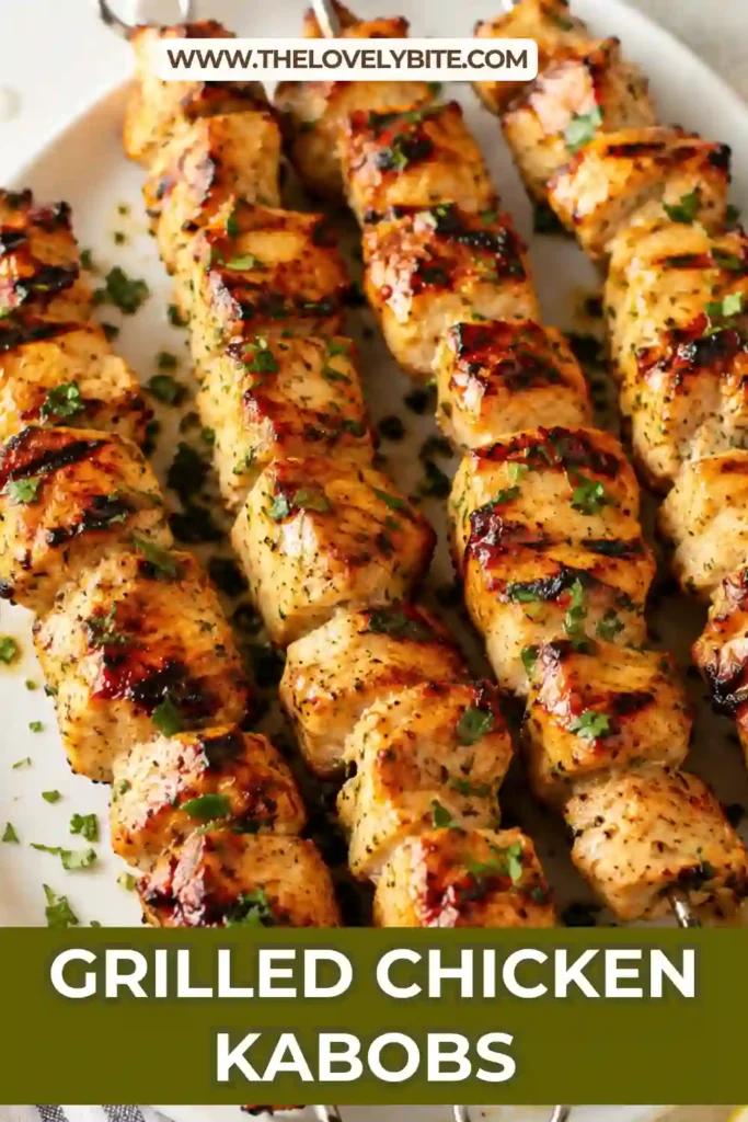 Close-up of grilled chicken skewers with paprika seasoning and char marks served on a white platter. The chicken looks juicy, tender, and perfectly cooked.