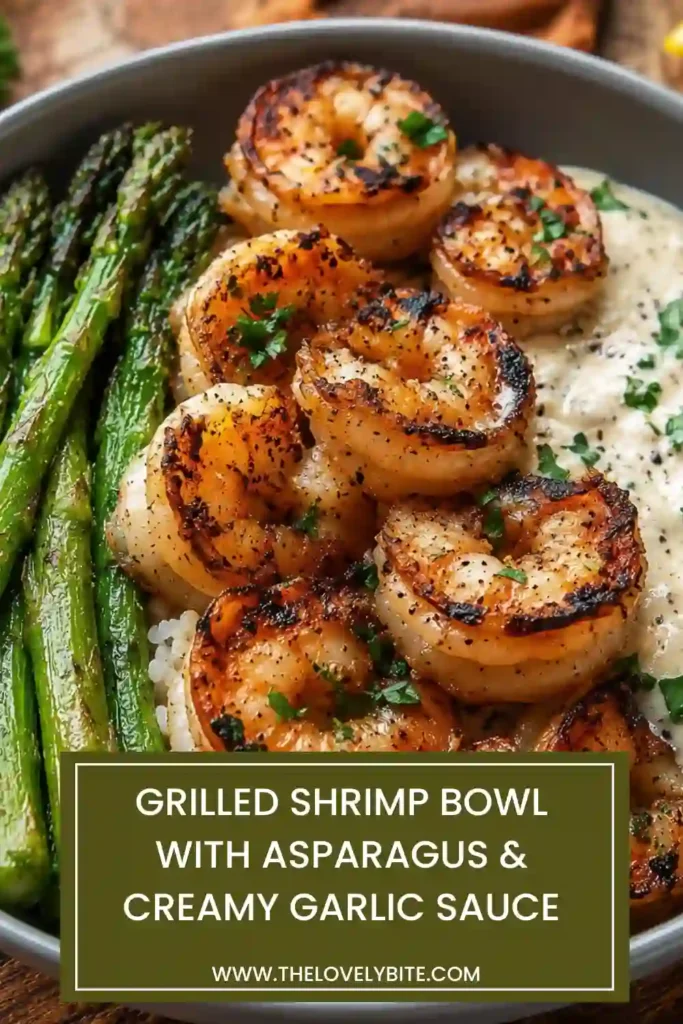 Fresh grilled shrimp served over rice with asparagus and creamy garlic sauce in a modern white bowl. The dish is garnished with Parmesan and parsley.