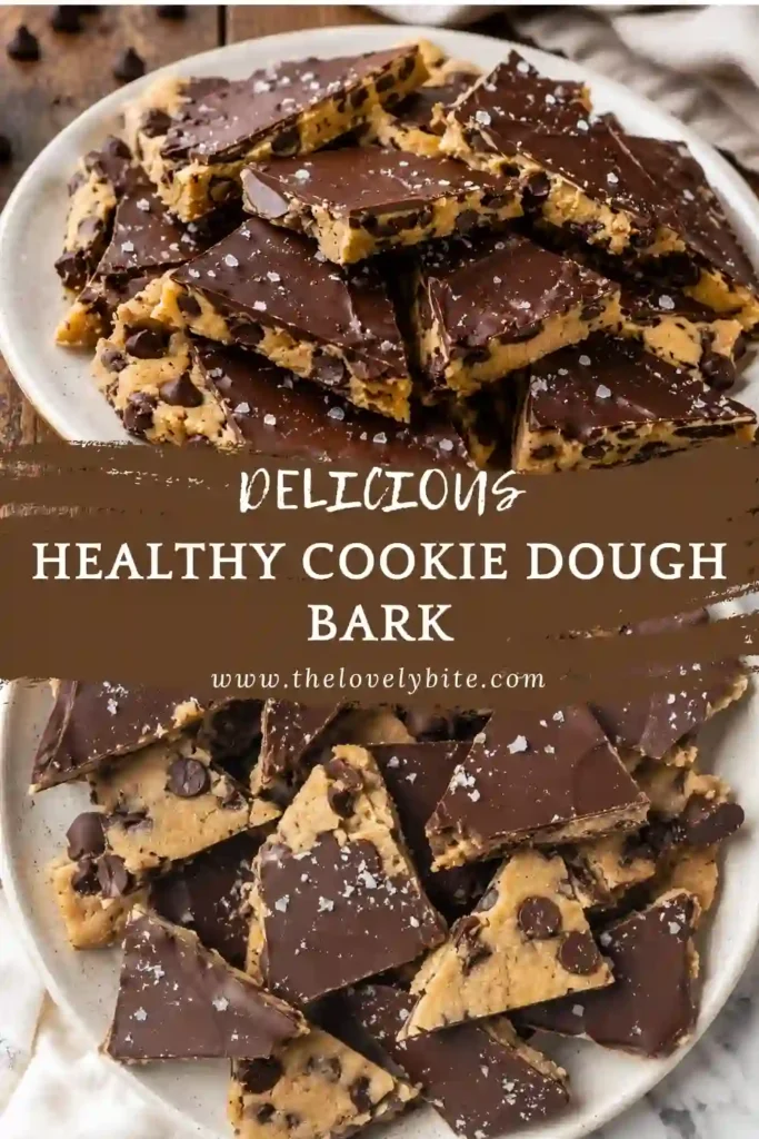 Healthy Cookie Dough Bark made with almond flour, maple syrup, and cashew butter is topped with melted dark chocolate and flaky sea salt. The bark is sliced into rustic pieces and served on parchment paper.