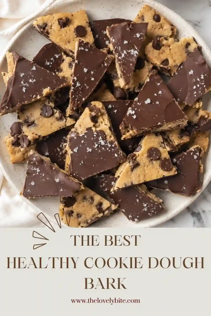 No bake cookie dough bark made with wholesome almond flour and chocolate chips sits on a serving platter. The smooth chocolate topping is sprinkled with flaky sea salt for added flavor.