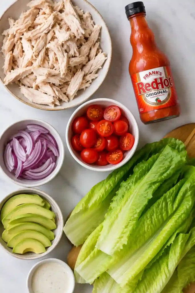 Easy Low Carb Buffalo Chicken Lettuce Wraps served fresh with creamy avocado and colorful vegetables. A delicious gluten-free recipe for keto meal planning.