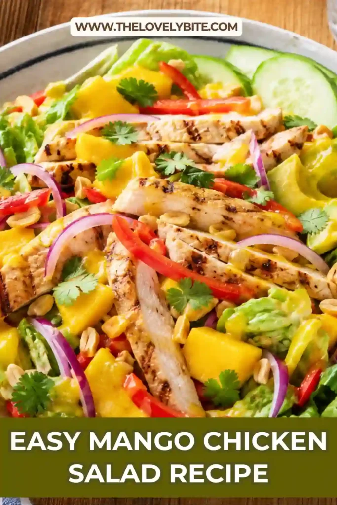 A colorful Mango Chicken Salad with grilled chicken, fresh mango slices, avocado, mixed greens, herbs, and chopped peanuts drizzled with mango lime vinaigrette.