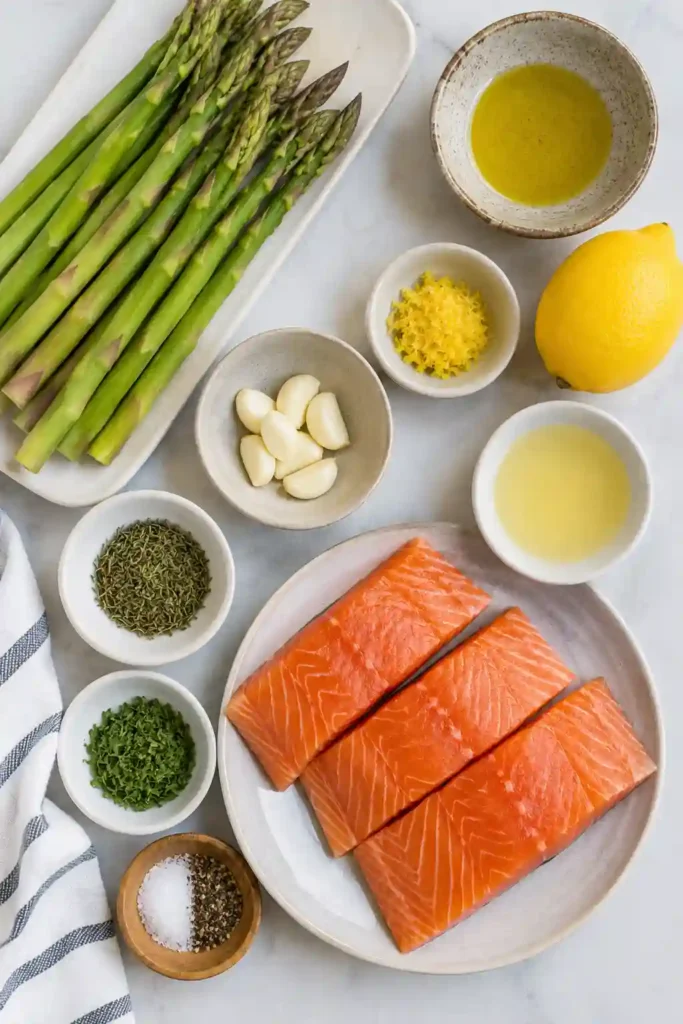 Golden baked Sheet Pan Lemon Herb Salmon with Asparagus served fresh from the oven. The salmon is topped with lemon slices and herbs beside perfectly roasted asparagus.