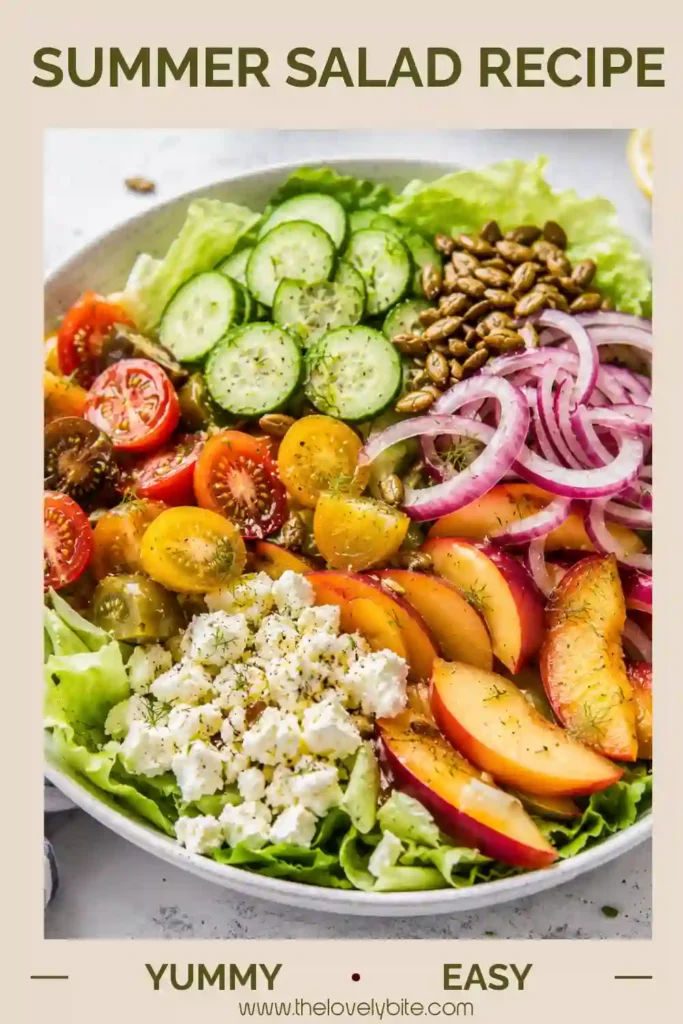 Fresh butter lettuce salad topped with ripe peaches, cucumber slices, cherry tomatoes, feta cheese, cilantro, and pumpkin seeds in a large serving bowl.