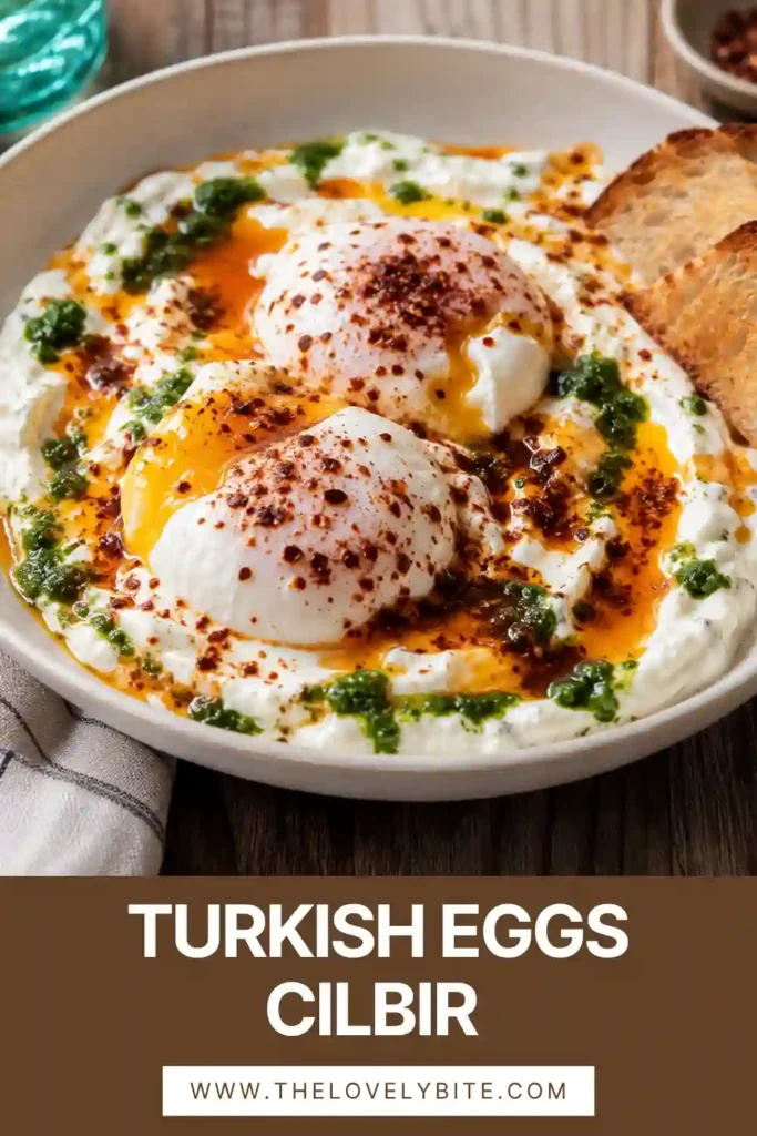 Close-up of Turkish Eggs (Cilbir) topped with warm paprika butter, fresh dill, and flaky sea salt served over thick Greek yogurt.