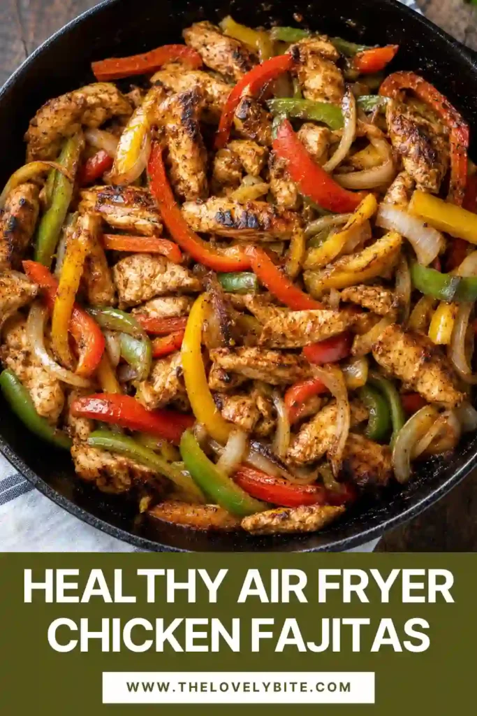 Close-up of air fryer chicken fajitas featuring juicy chicken strips, red and yellow peppers, and caramelized onions. The chicken fajitas are served with tortillas, lime, and guacamole.