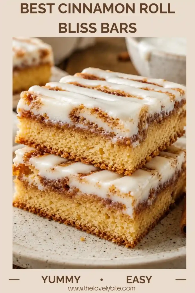Best Cinnamon Roll Bliss Bars with golden cinnamon swirls, a creamy center and thick vanilla glaze. The sliced dessert bars show distinct layers of soft cake and cream cheese filling.