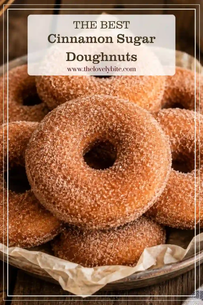 Close-up of fluffy Cinnamon Sugar Doughnuts covered in a golden cinnamon sugar coating. The homemade yeast doughnuts show their soft interior and lightly crisp fried surface.