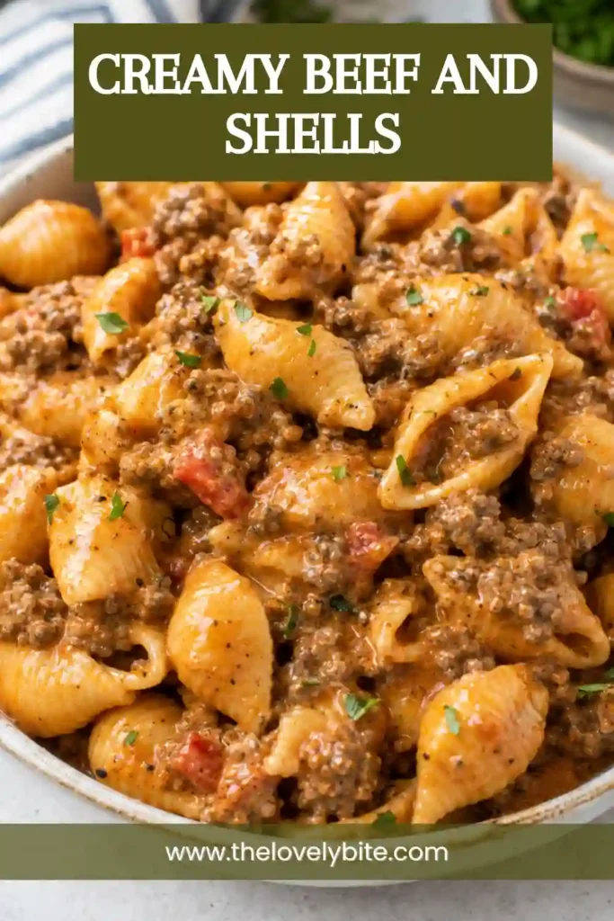 Cheesy beef and shells served hot from a skillet with ground beef, tender pasta, and creamy tomato cheddar sauce. Fresh parsley is sprinkled over the finished pasta.