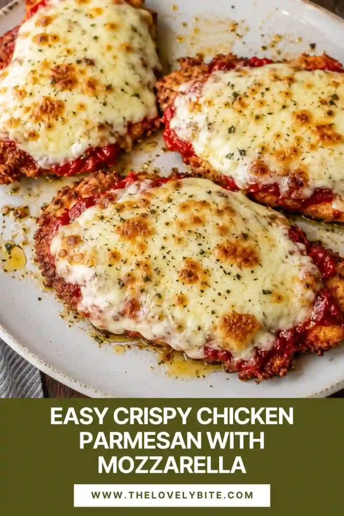 Golden Crispy Chicken Parmesan covered with tomato sauce and melted mozzarella. The crunchy Parmesan breadcrumb crust remains visible around the edges of each chicken cutlet.