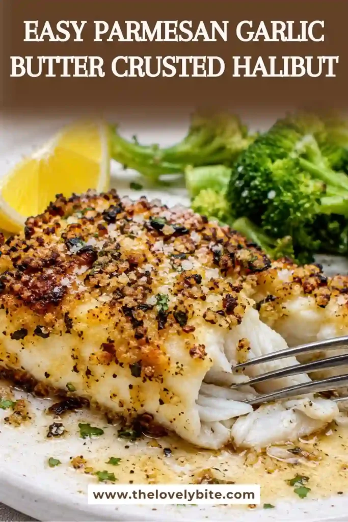 Parmesan Garlic Butter Crusted Halibut plated with roasted vegetables and fresh lemon slices. The baked fish has a crispy golden topping and tender flaky interior.