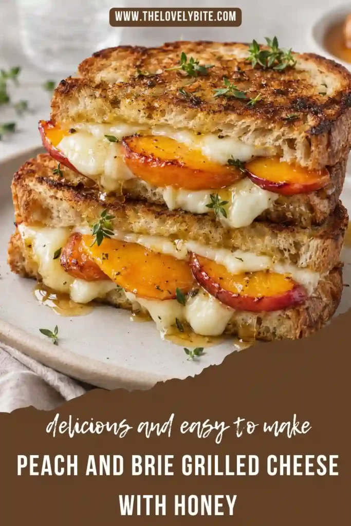 Brie and peach sandwich with melted cheese, seared fresh peaches, honey, and thyme on buttery toasted sourdough. The sandwich is sliced diagonally to reveal the creamy fruit and cheese filling.